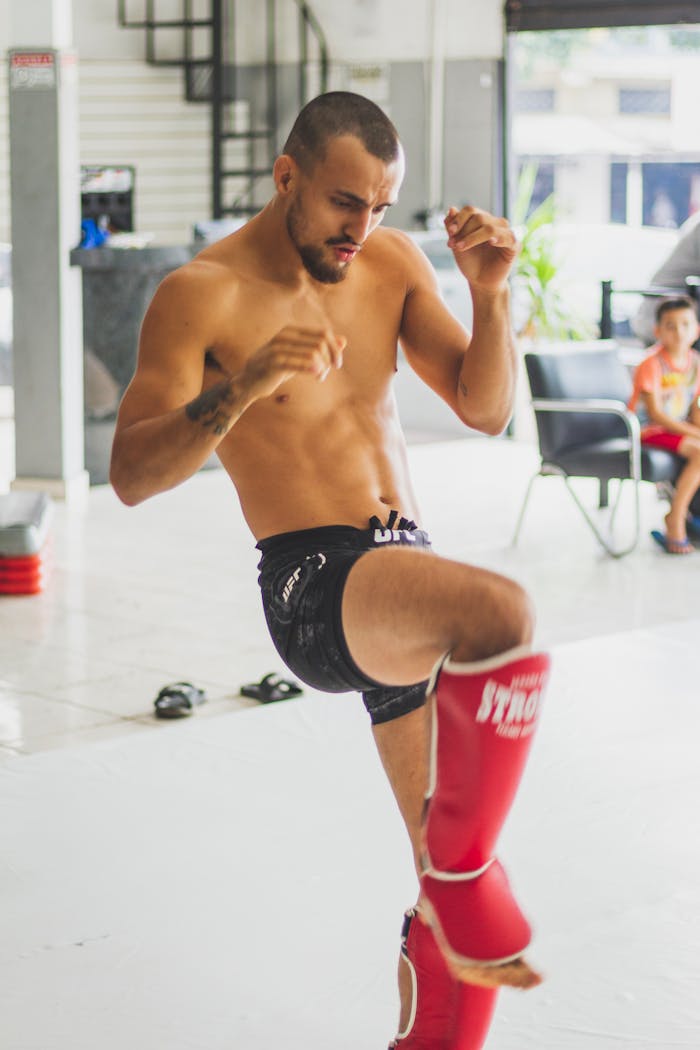 Topless Man in Black Shorts Holding Red and White Coca Cola Cup